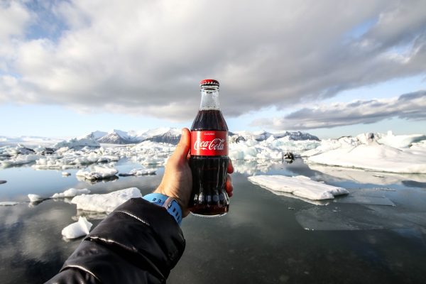 A person has Coco Cola bottle in hand